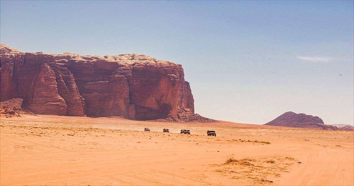 widok na pustynię w Jordanii z widocznymi skałami i autami terenowymi