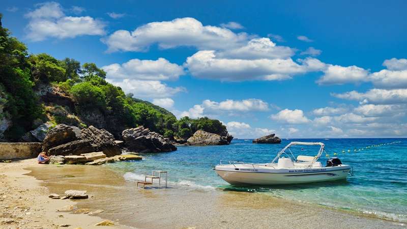 łódź przy pięknej plaży zatoczki Liapades Bay na wyspie Korfu