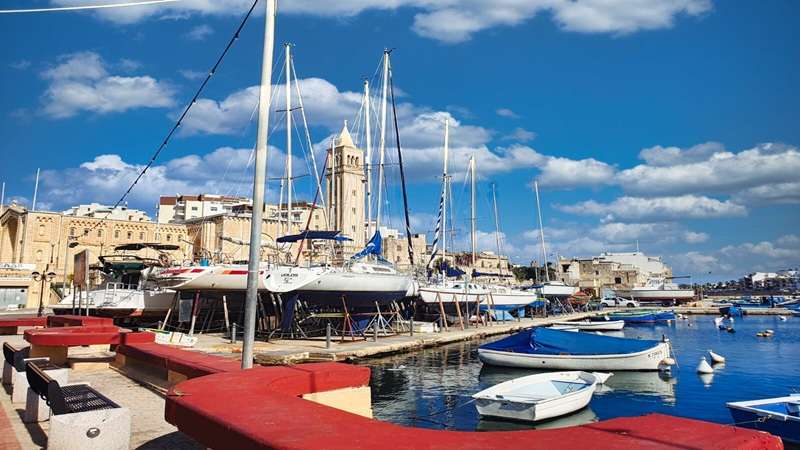 marina w mieście Valetta z wieloma łodziami oraz Starym Miastem w tle