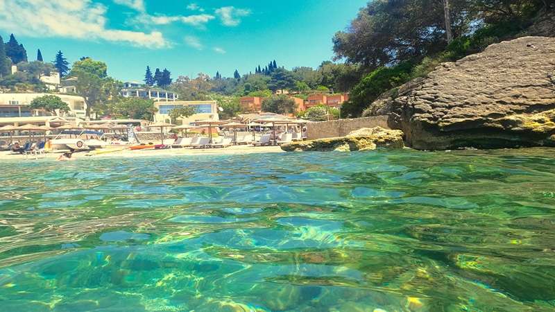 turkusowa woda i skały przy pięknej plaży w Liapades Bay na Korfu